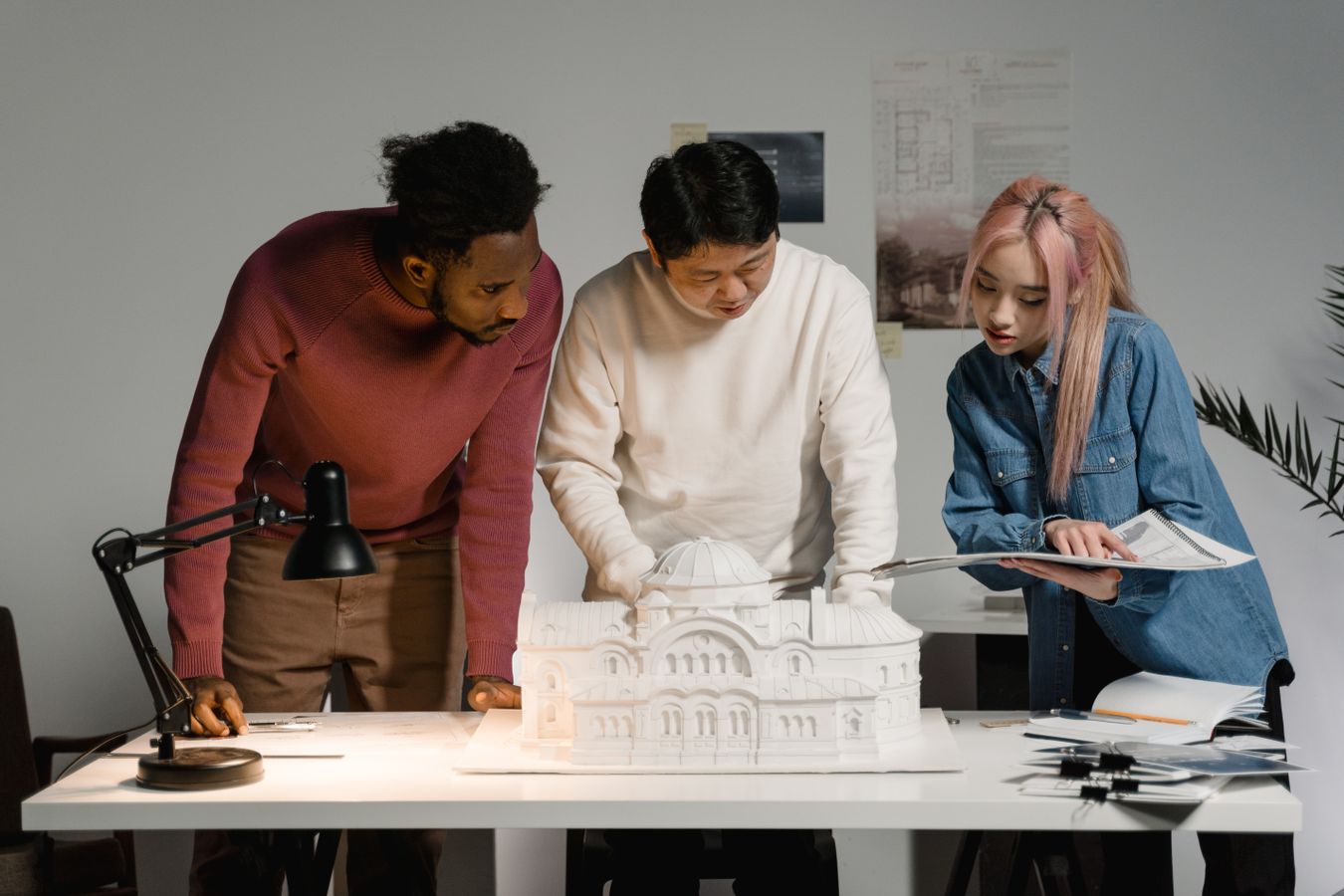 Team av arkitekter samlas kring en arkitekturmodell på ett kontor i Stockholm