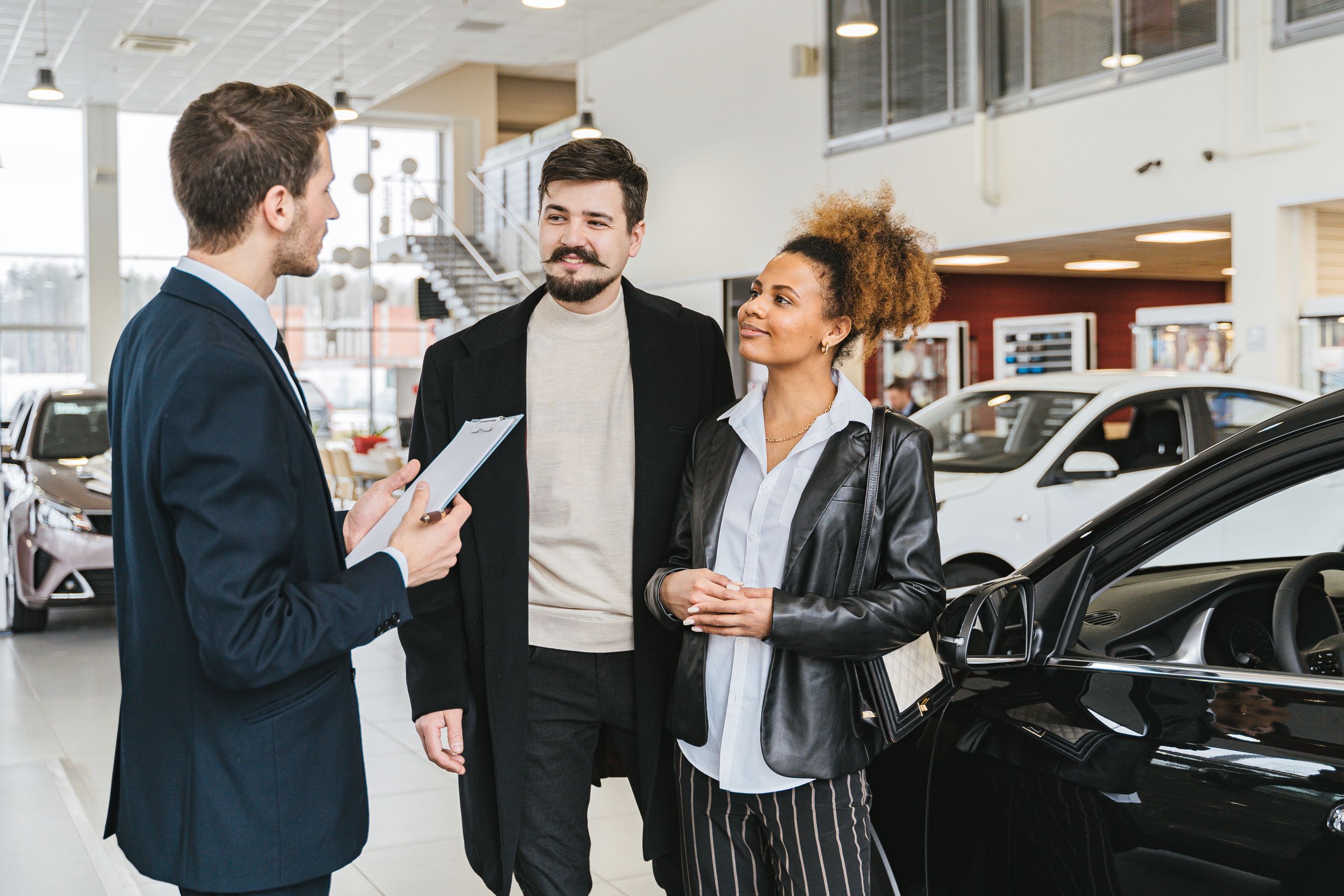 Bilsäljare rådgiver kund i showroom hos en bilhandlare i Stockholm