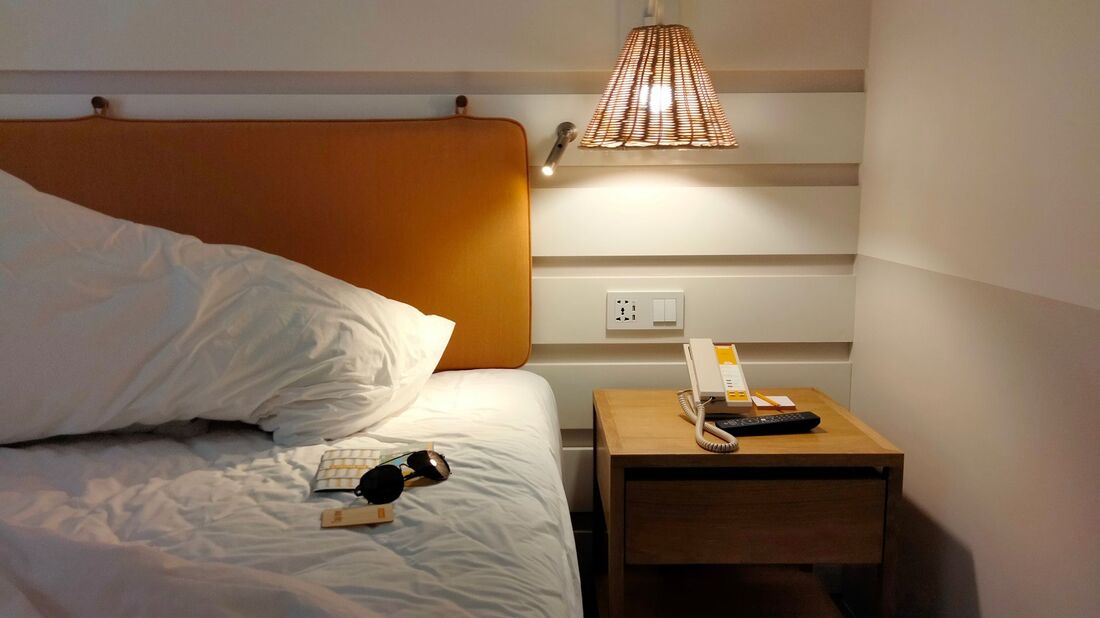 Modernt hotellrum med sänglampa och nattduksbord