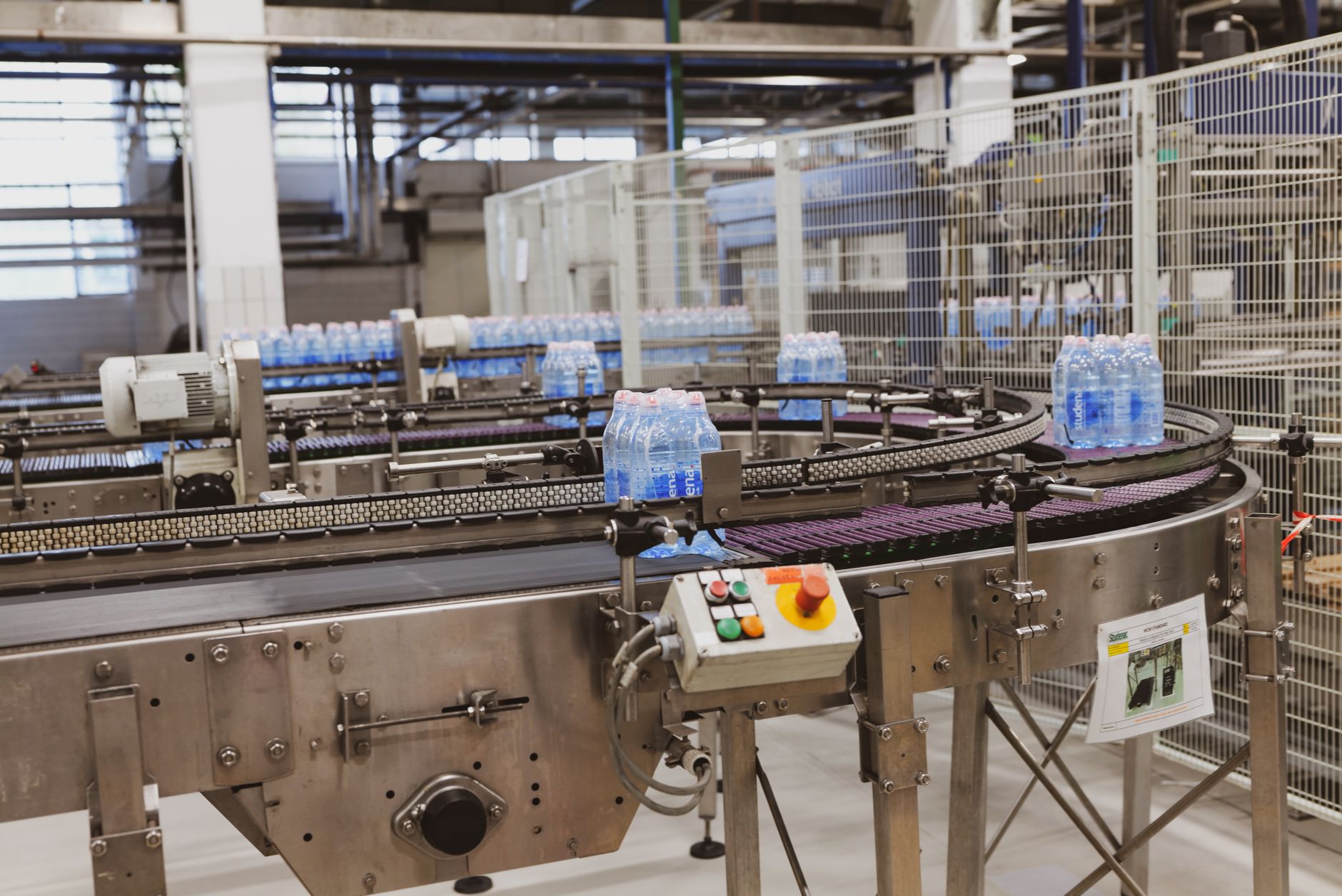 Industriarbetare arbetar vid tillverkningsmaskiner i en modern produktionshall