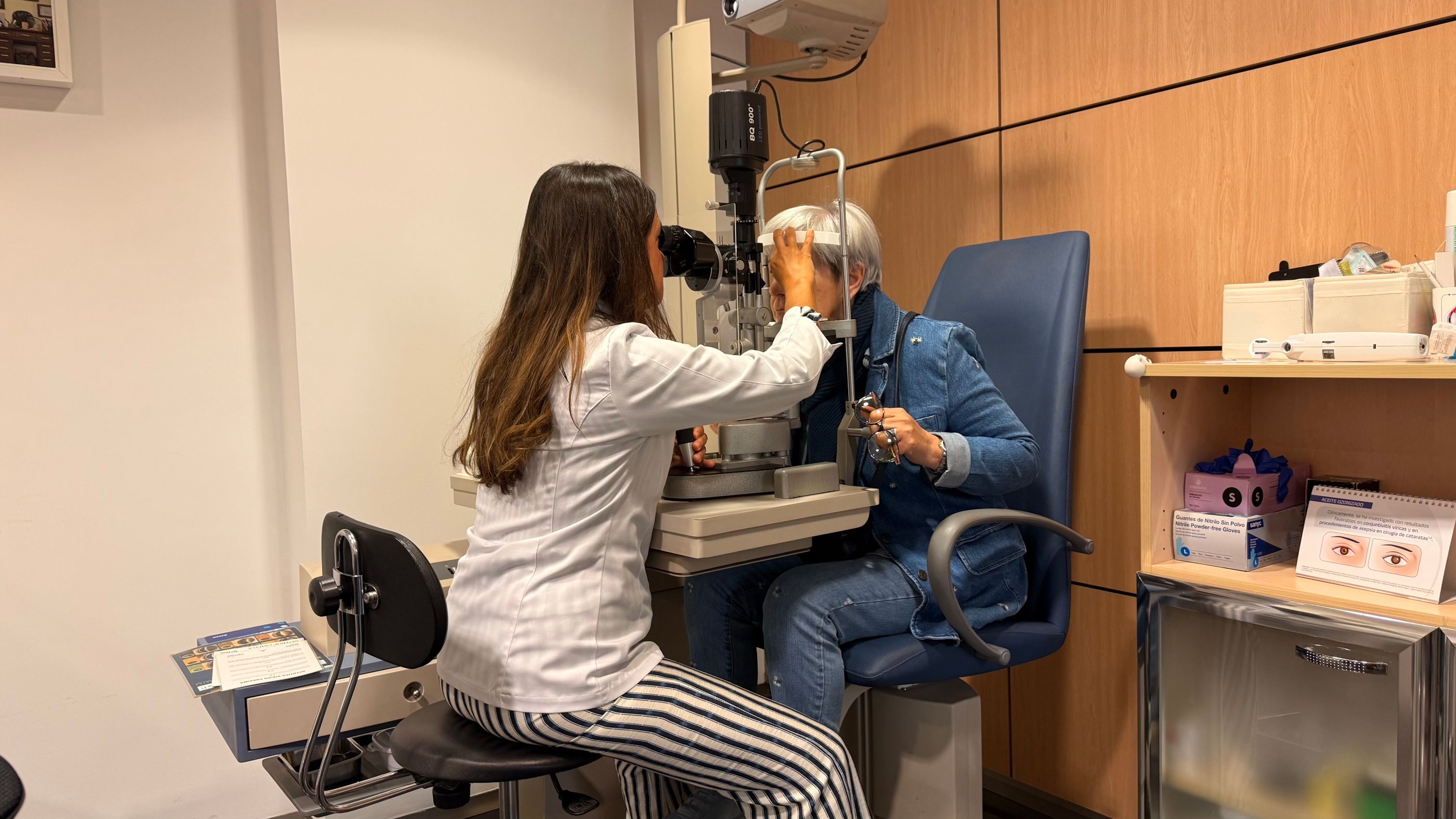 Ögonläkare undersöker patient med spaltlampa på modern ögonklinik i Stockholm