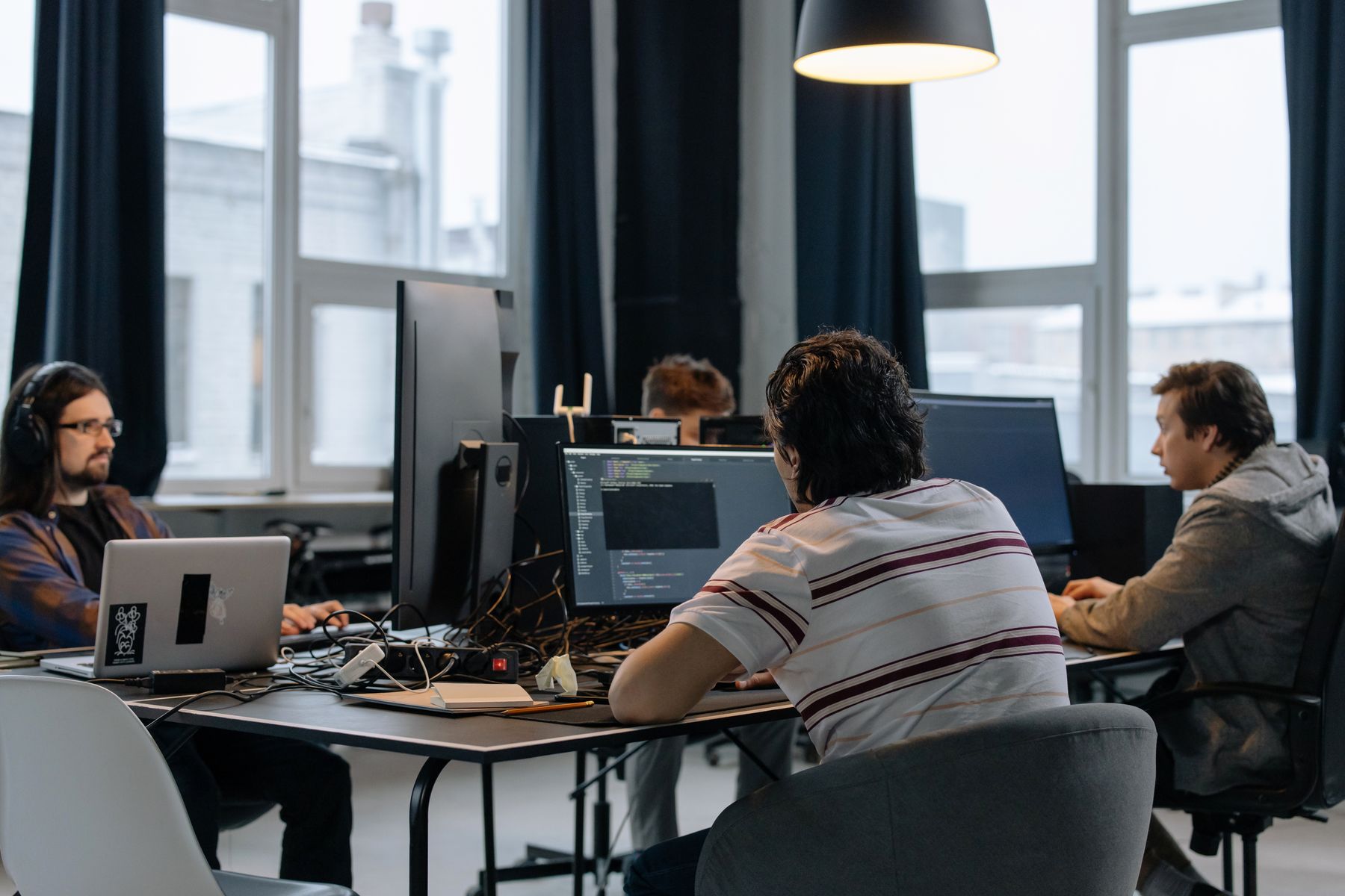Utvecklarteam samarbetar kring skärmar på ett modernt SaaS-kontor