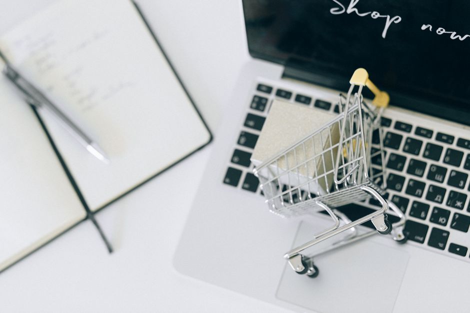 Kund handlar från en Shopify-butik på laptop med kort i handen