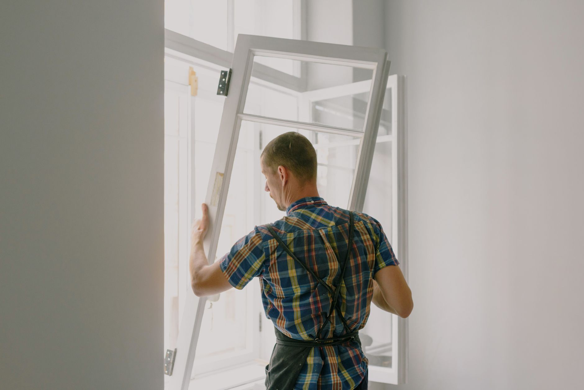 Hantverkare installerar nytt fönster i lägenhet i Stockholm