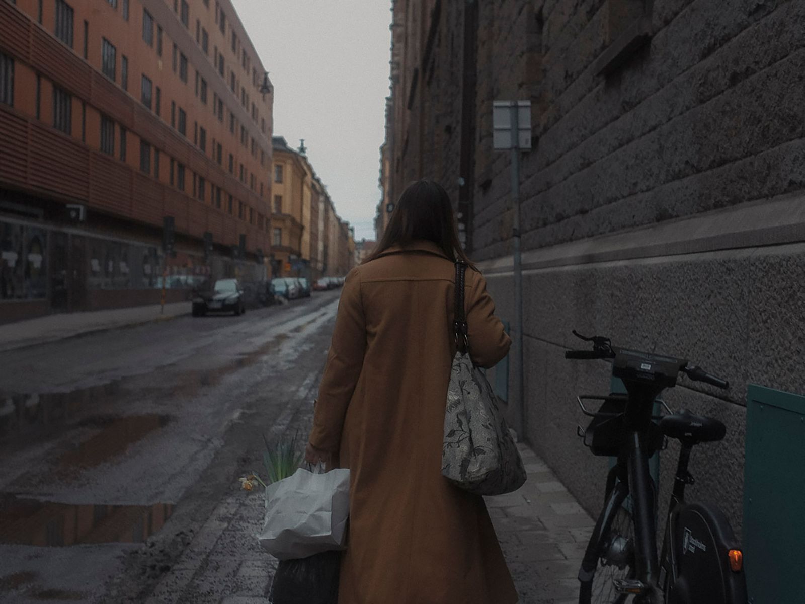 Person med shoppingkassar går längs en central gata i Norrmalm, Stockholm