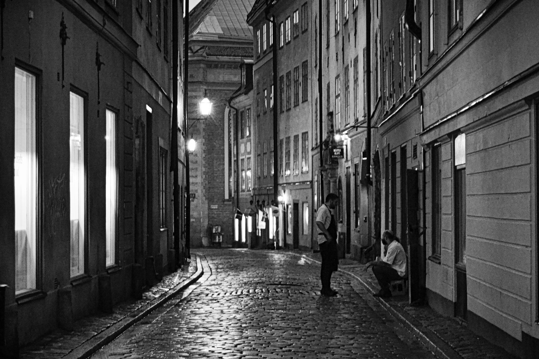 Historisk gata i centrala Norrmalm, Stockholm, med belysta fasader kvällstid