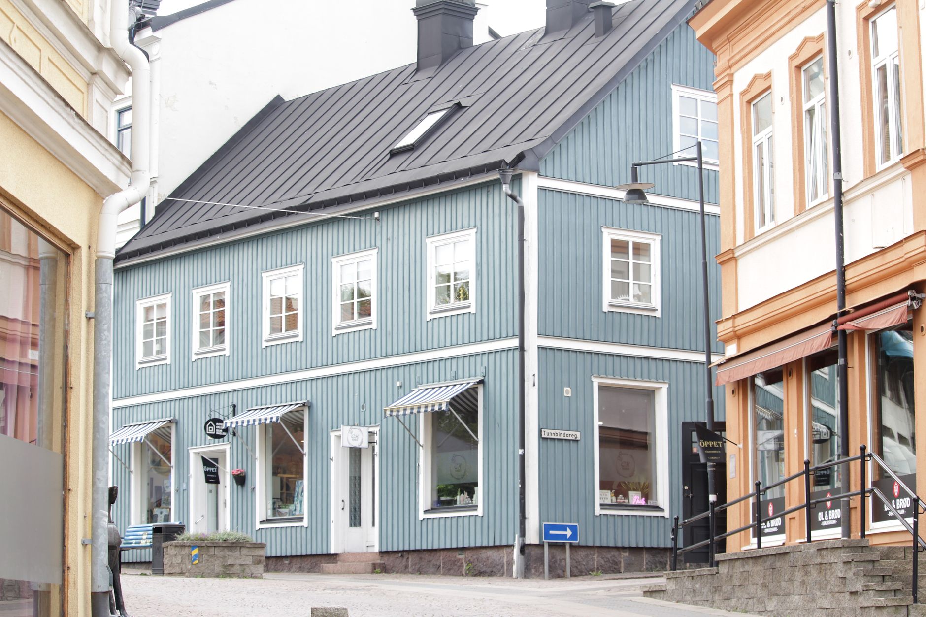 Smal gata kantad av lokala butiker och kaféer med markiser, typisk för handeln kring Sundbybergs centrum