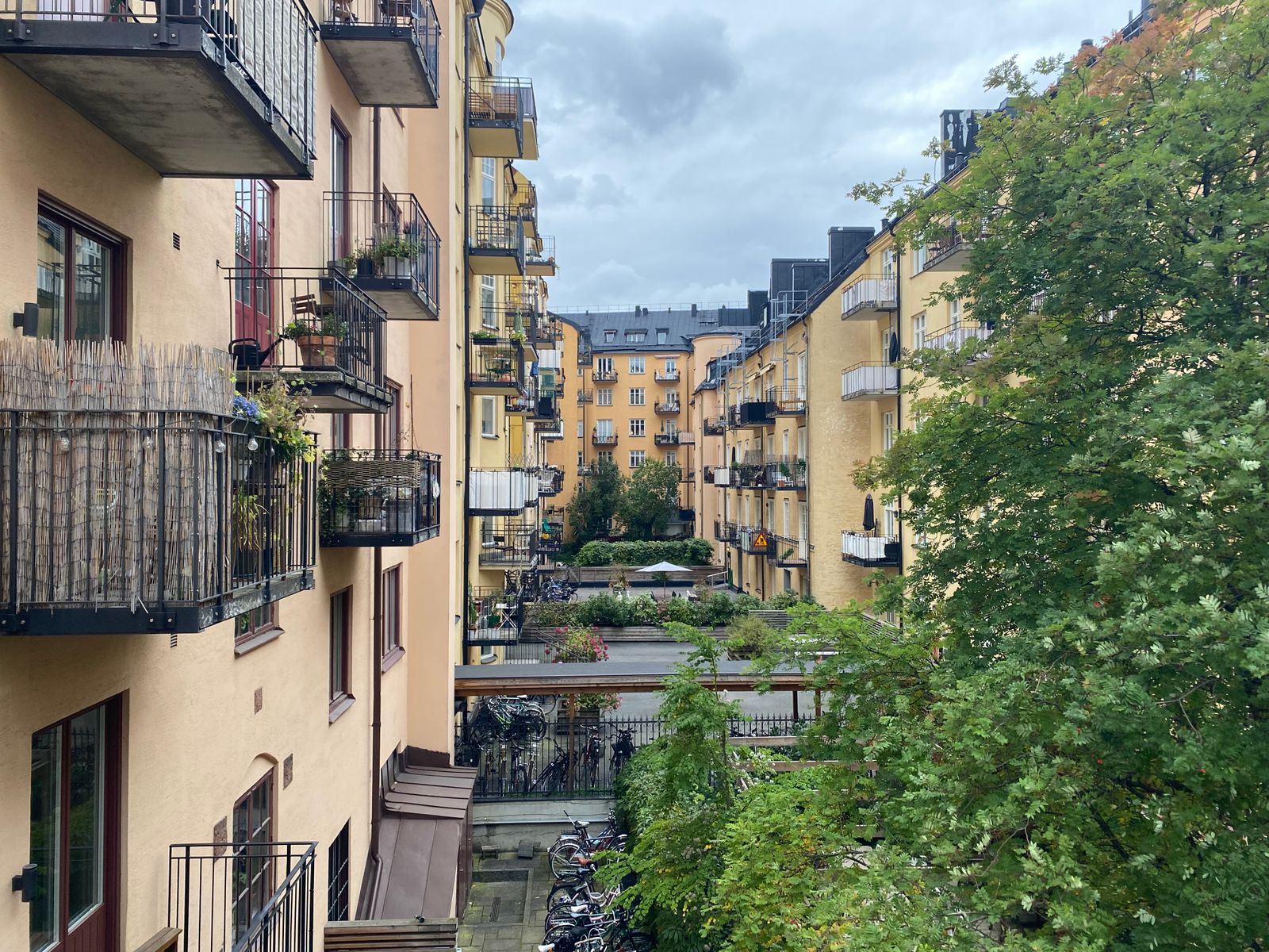 Innergård med gula sekelskifteshus, balkonger och cyklar i ett bostadskvarter i Vasastan