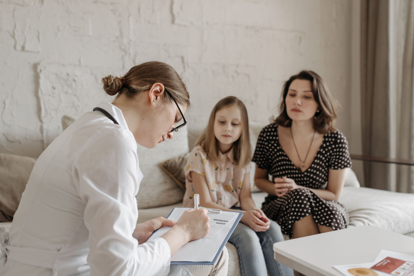 Läkare konsulterar en mamma och dotter på en familjeklinik i Vasastan